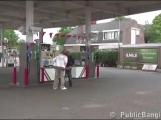 Muy embarazada joven mujer público trío en un gas estación